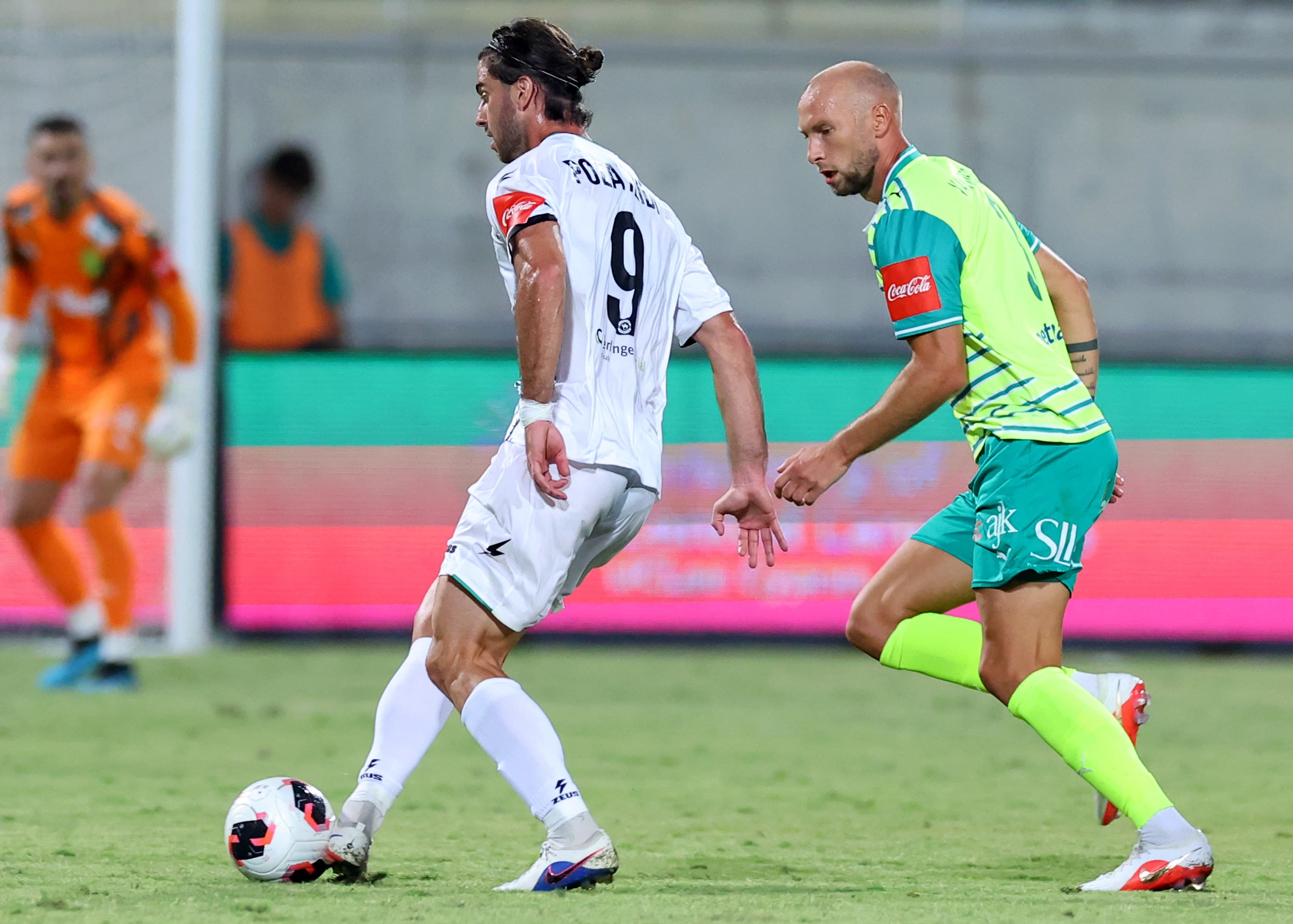 An Akritas player presses an AEK Larnaca opponent in possession
