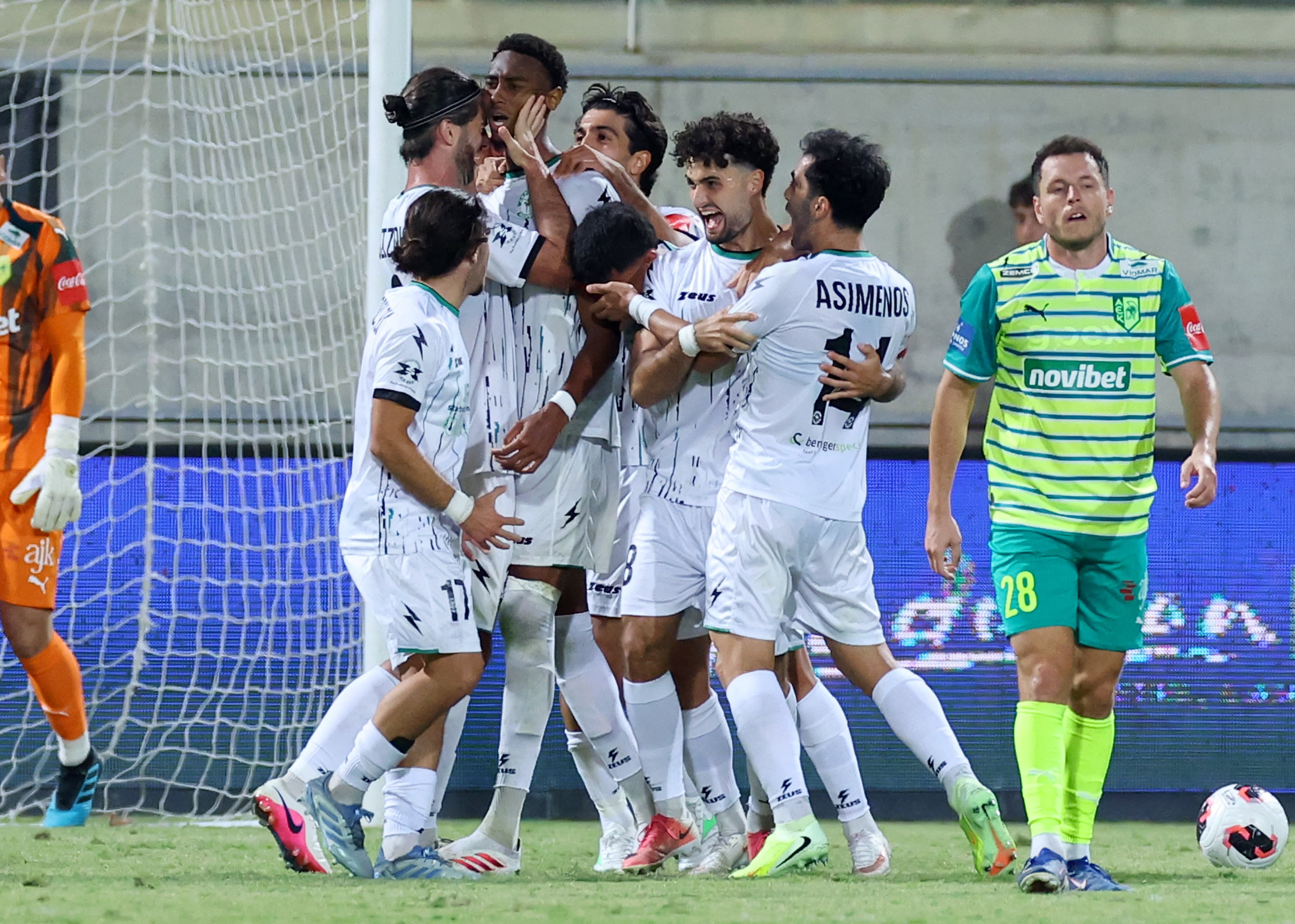 AEK Larnaca players celebrate while an Akritas player looks on